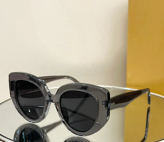 Black sunglasses on a reflective surface with a neutral background